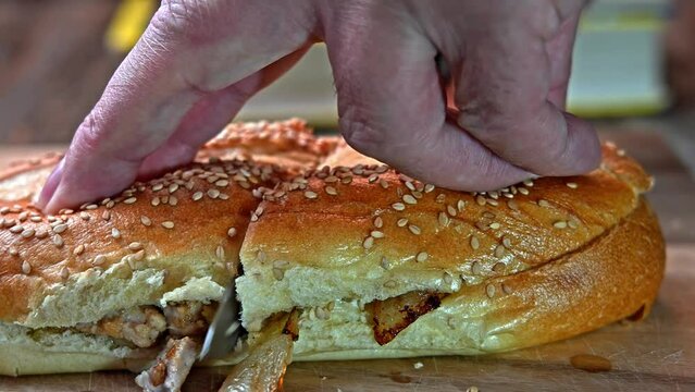 Close up from cutting  sandwich with fried pork meat and fried onions