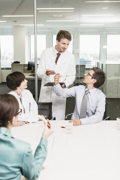 Colleagues at a pharmaceutical company meeting with clients in a conference room. Munich, Bavaria, Germany