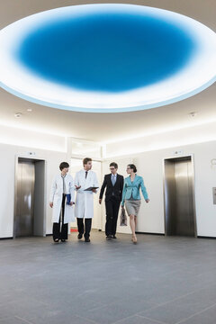 Colleagues at a pharmaceutical company meeting with a client in the foyer. Munich, Bavaria, Germany