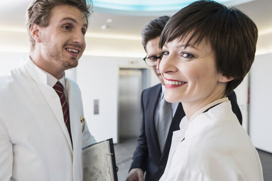 Colleagues at a pharmaceutical company meeting with a client in the foyer. Munich, Bavaria, Germany
