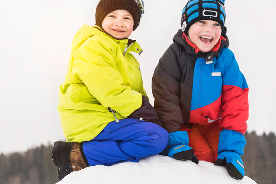 Two boys having a snowball fight and playing in the snow in winter. Wolfratshausen, Bavaria, Germany 