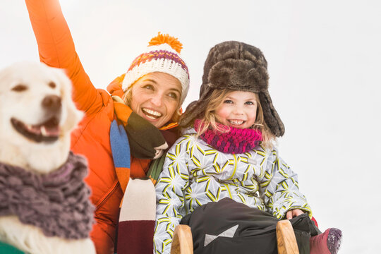 Mother and daughter smiling and playing in a snowy landscape in winter. Wolfratshausen, Germany