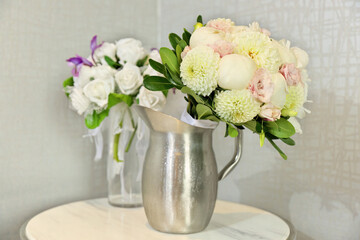 Beautiful Wedding Bouquets in Pitchers of Water on End Table Indoors