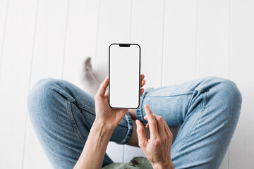 Young woman using smartphone with blank white screen for web site design, app for mobile phone and...