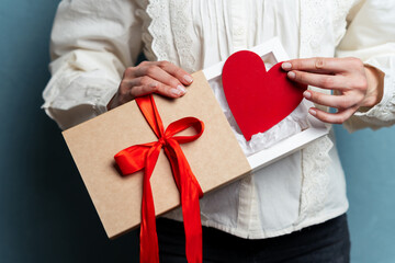 Cherished Moments: Unwrapping Love. Female holding gift box with red heart