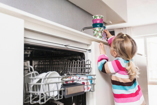 Young girl helping her dad with the dishes. Munich, Germany