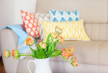 Beautiful orange tulips bouquet on wooden table in the living room