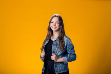 Fototapeta premium Smiling girl over yellow background. Emotion concept