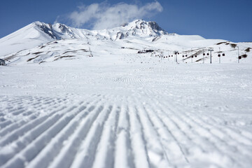 Grader tracks in the snow. Freshly laid track at mountain ski resort. Distant perspective on the...
