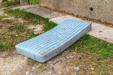 Discarded old mattress and box spring in alley.
