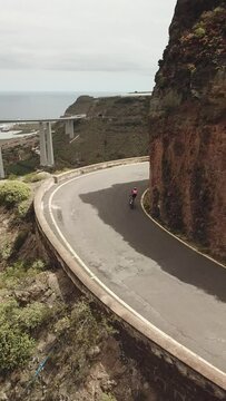 Race of cyclists in the Canary Islands, Cyclists between Mountains, Difficult Roads of Gran Canaria. Vertical Drone Recorded Cycling to 4K Quality.
