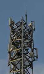 Spitze eines Funkmastes mit vielen Ger&auml;ten und blauem Himmel im Hintergrung.