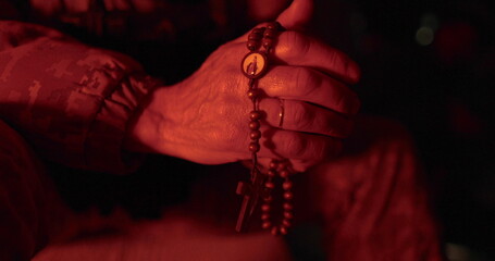 Soldiers pray with rosaries in their hands. Close-up of hands of vicar with rosary during prayer. They prayed for military time. Man prays.