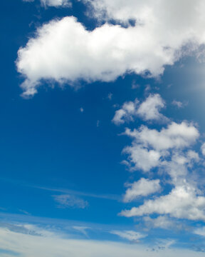 Cumulus clouds and blue sky. Vertical photo.