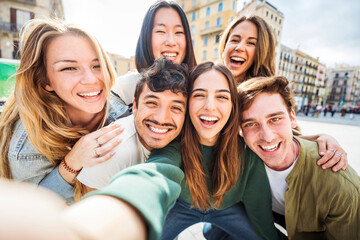 Multicultural young people smiling together at camera outside - Happy group of friends taking...