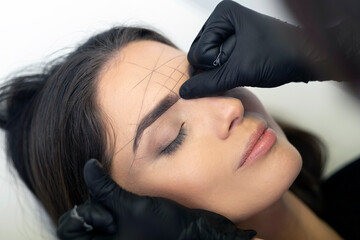 Eyebrow shape correction in a professional salon.