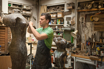 Young artist working on a sculpture in an atelier. Munich, Bavaria, Germany