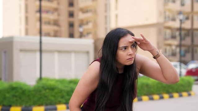 Indian Woman Looking Around With Hand On Forehead