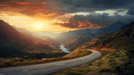 Fototapete Grau A curvy road winds through the mountains in sunset