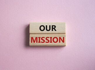 Our Mission symbol. Concept word Our Mission on wooden blocks. Beautiful pink background. Business and Our Mission concept. Copy space