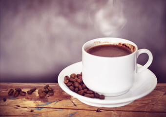 Coffee cup and coffee beans on a wooden table