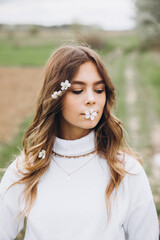 
portrait of a young girl with long hair and flowers on her head on the street. spring portrait. Awakening female beauty