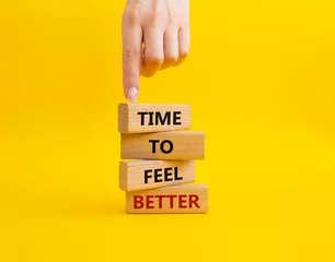 Foto op Plexiglas Time to feel better symbol. Wooden blocks with words Time to feel better. Businessman hand. Beautiful yellow background. Medicine and Time to feel better concept. Copy space. © Natallia