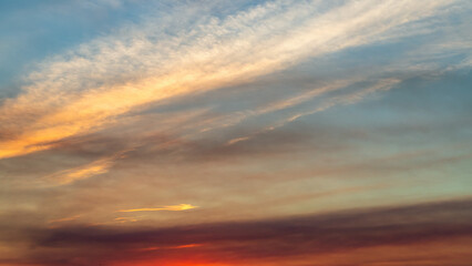 Sunset sky on twilight in the evening with orange gold sunset cloud nature sky backgrounds. Romantic summer sky at sunset.