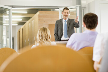 Motivational speaker and business coach holding a business coaching seminar for young professionals at a start-up business.