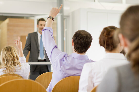 Motivational speaker and business coach holding a business coaching seminar for young professionals at a start-up business.