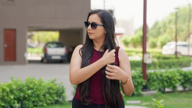 Confident Indian Woman with Sunglasses setting her Hair
