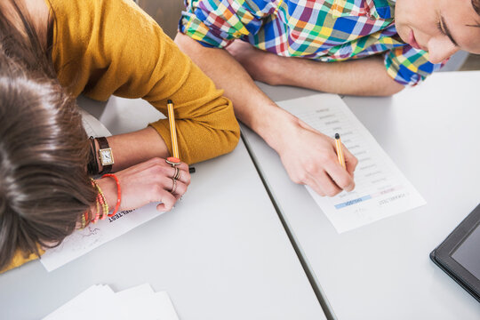 Studenten H&auml;nde am Test ausf&uuml;llen im Klassenzimmer, Vogelperspektive