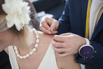 Fashion designer making the finishing touches to a wedding gown on a beautiful woman. Munich, Bavaria, Germany