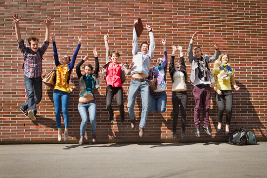Group of students on campus jumping for joy. Munich Germany
