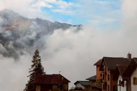 Clouds and Peaks: A Village Morning at the Foot of Whispering Alpine Giants - Powered by Adobe
