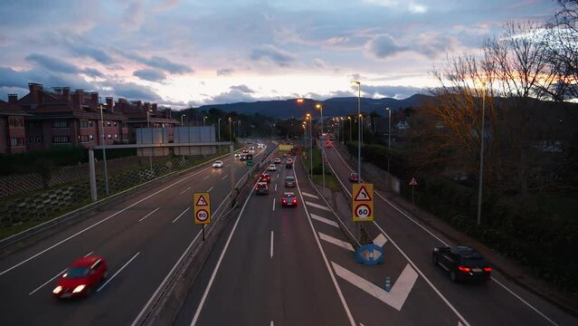 Atardecer naranja sobre una autopista con trafico