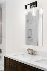 A bathroom faucet detail with a bronze widespread faucet, white marble countertop, and a dark wood cabinet.