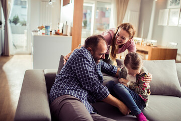 Happy family playing at home with child