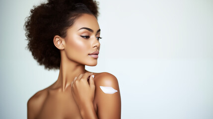 Skin care concept with smear of white cream on black woman's shoulder