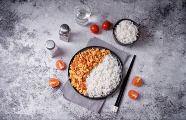 Tomato and eggs stir fry with rice in a plate