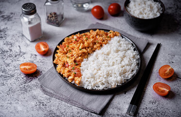 Tomato and eggs stir fry with rice in a plate - obrazy, fototapety, plakaty