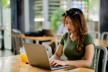 Asian woman sitting and working with laptop Print and work online