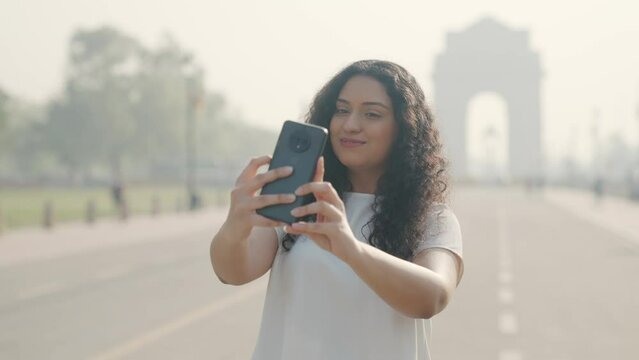 Indian Girl with Curly Hair Taking Selfie at India Gate