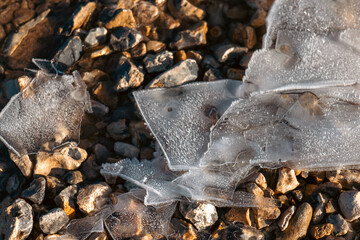 frozen sheets of ice on a gravel path