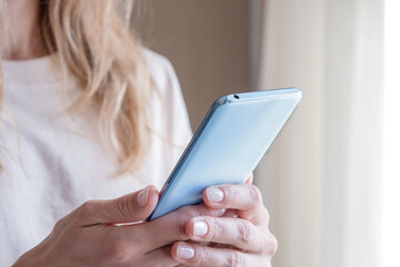 closeup of unrecognizable person in home clothes using phone