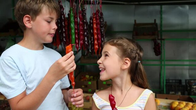 Yappy boy and girl eat churchhela sweets in market 