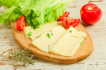 Some slices of cheese with vine tomatoes and some lettuce leaves