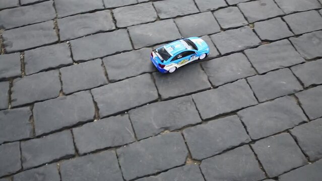 Radio controlled toy car Chevrolet move on pavement.