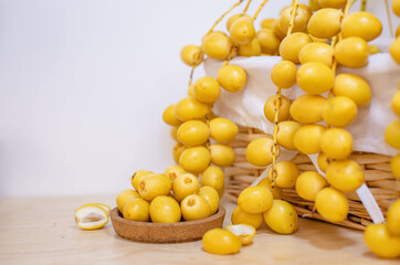 Close up and selective focus fresh dates fruits in wooden plate.	