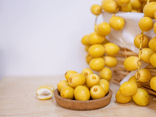 Close up and selective focus fresh dates fruits in wooden plate.	